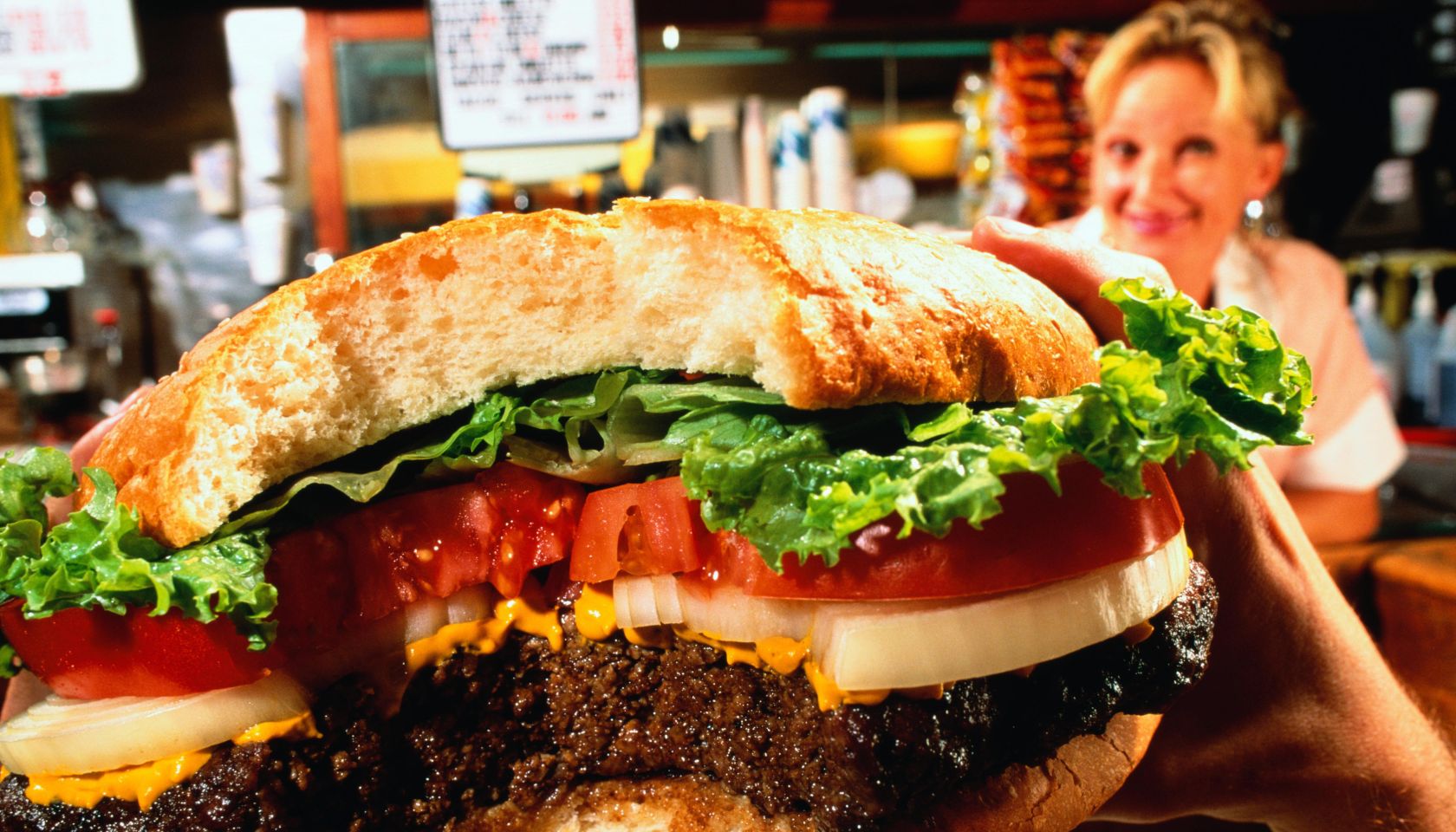 Hamburger, close-up, waitress in background (wide angle)