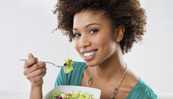 Close-up Of Beautiful African American Woman Eating Salad At Home