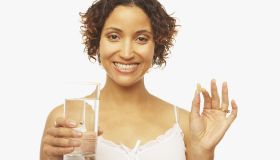 Mixed Race woman holding vitamin