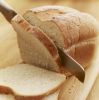Knife slicing loaf of bread
