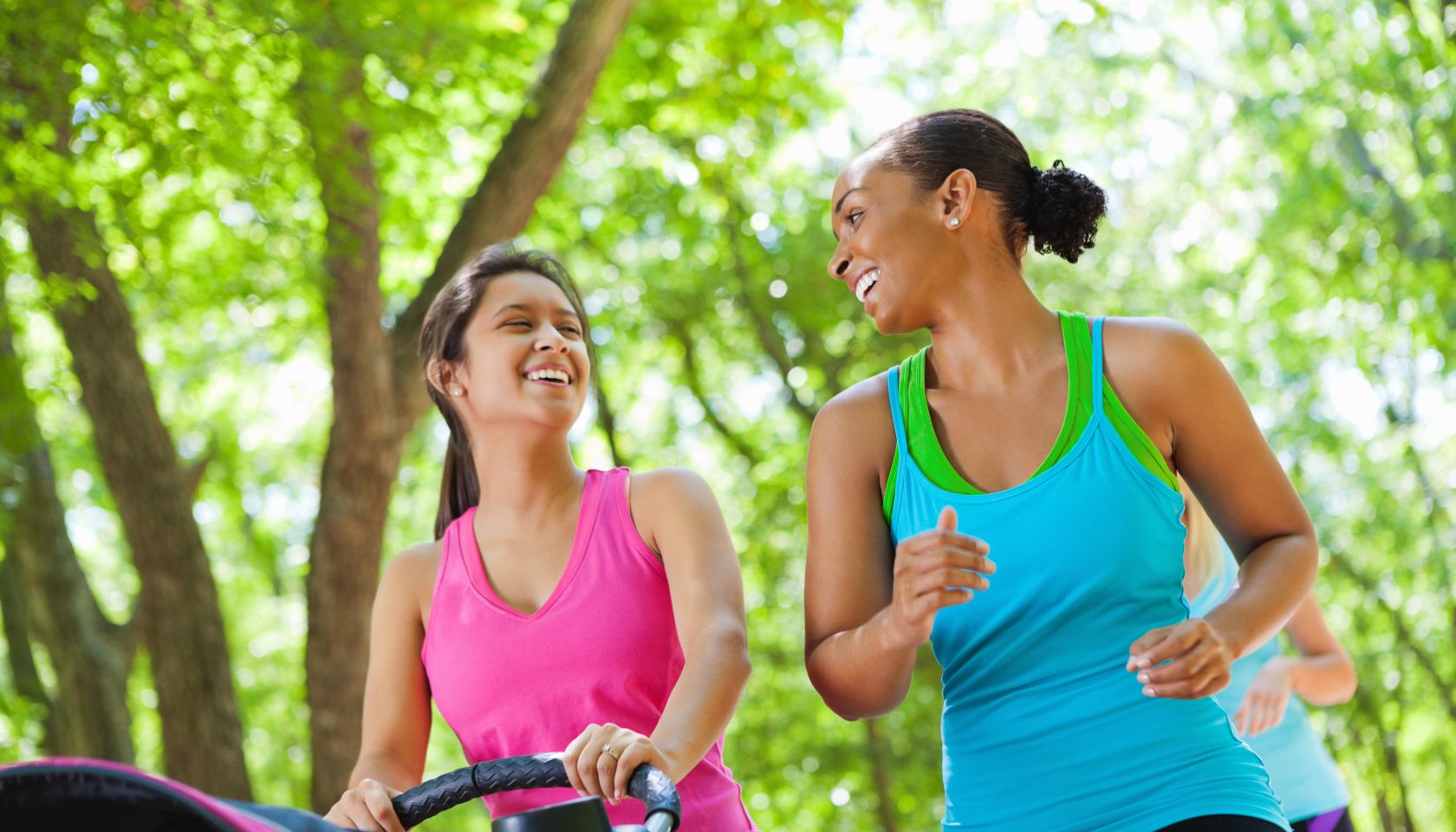 Happy women walking together in park with baby strollers