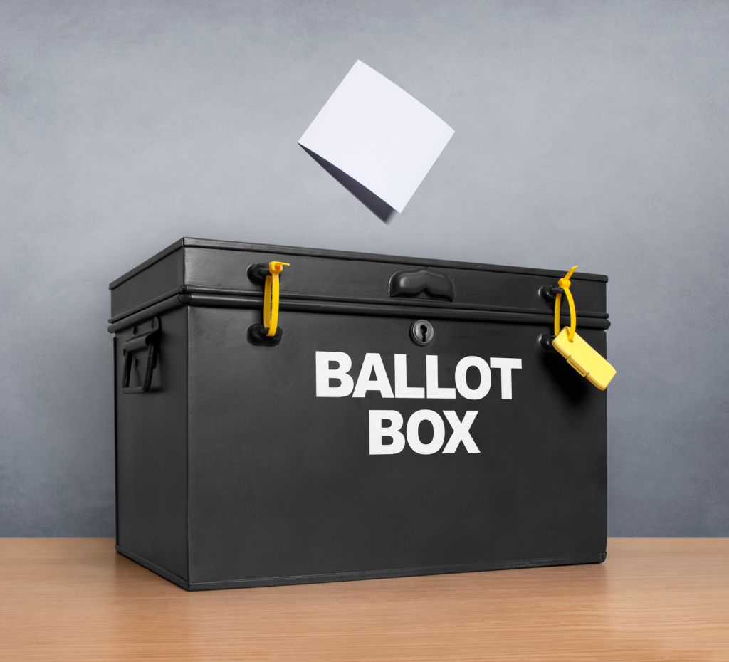Ballot paper poised above the ballot box