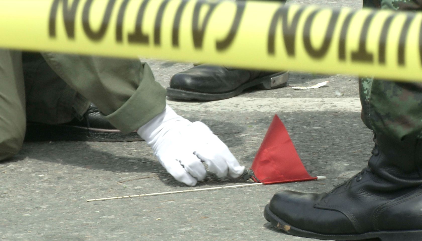 Thai police crime scene investigators search near the clock...