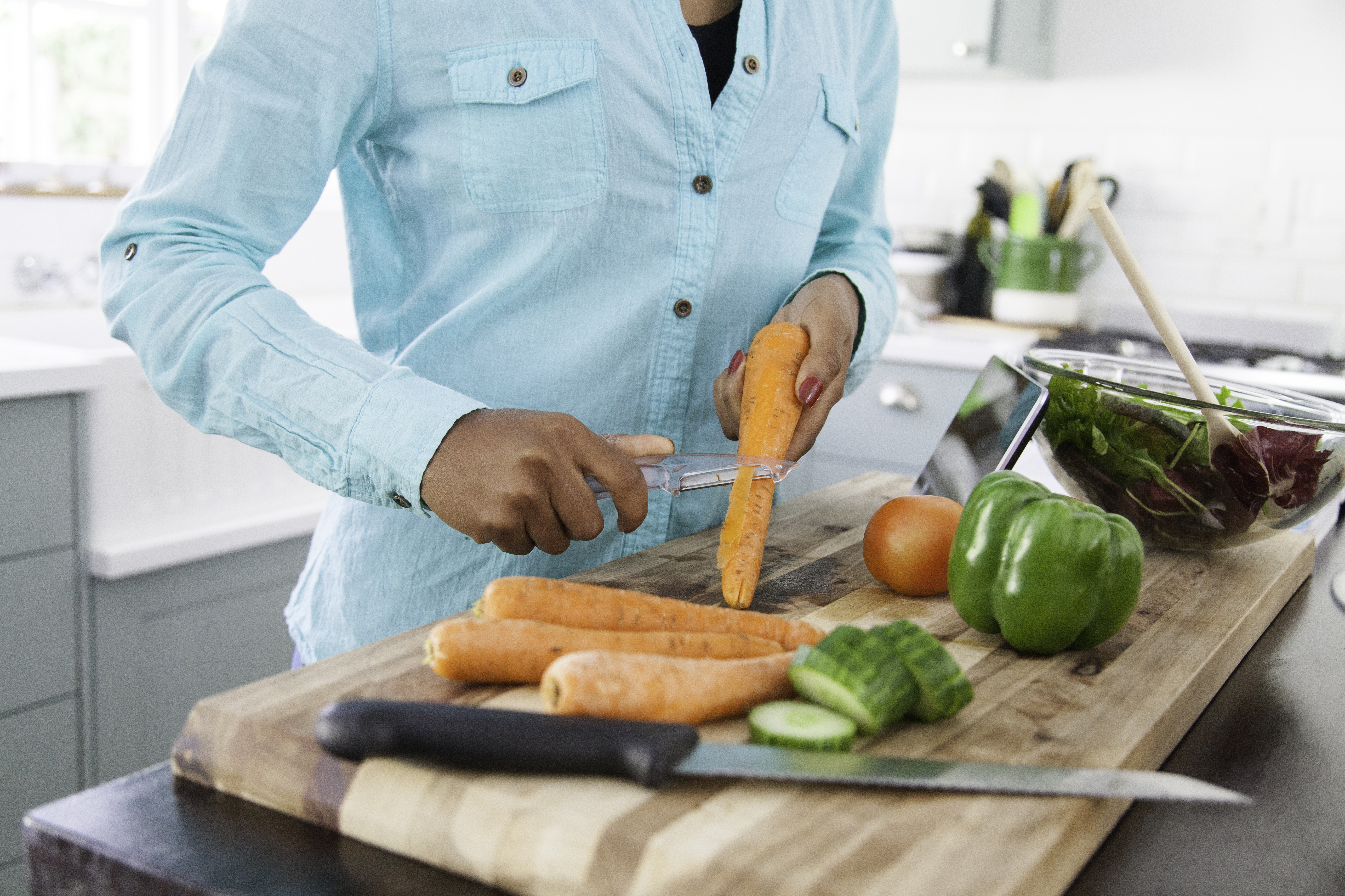 African woman peeling carrots in the kitchen.