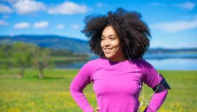 Woman relaxing from exercising in nature, wearing smart technology