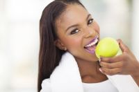 healthy african woman eating apple