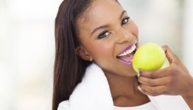 healthy african woman eating apple