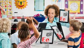 Teacher and students learning alphabet with digital tablets