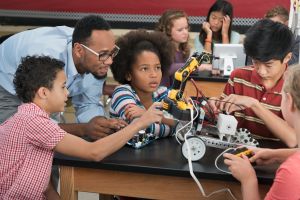 Teacher helping students in robotics class