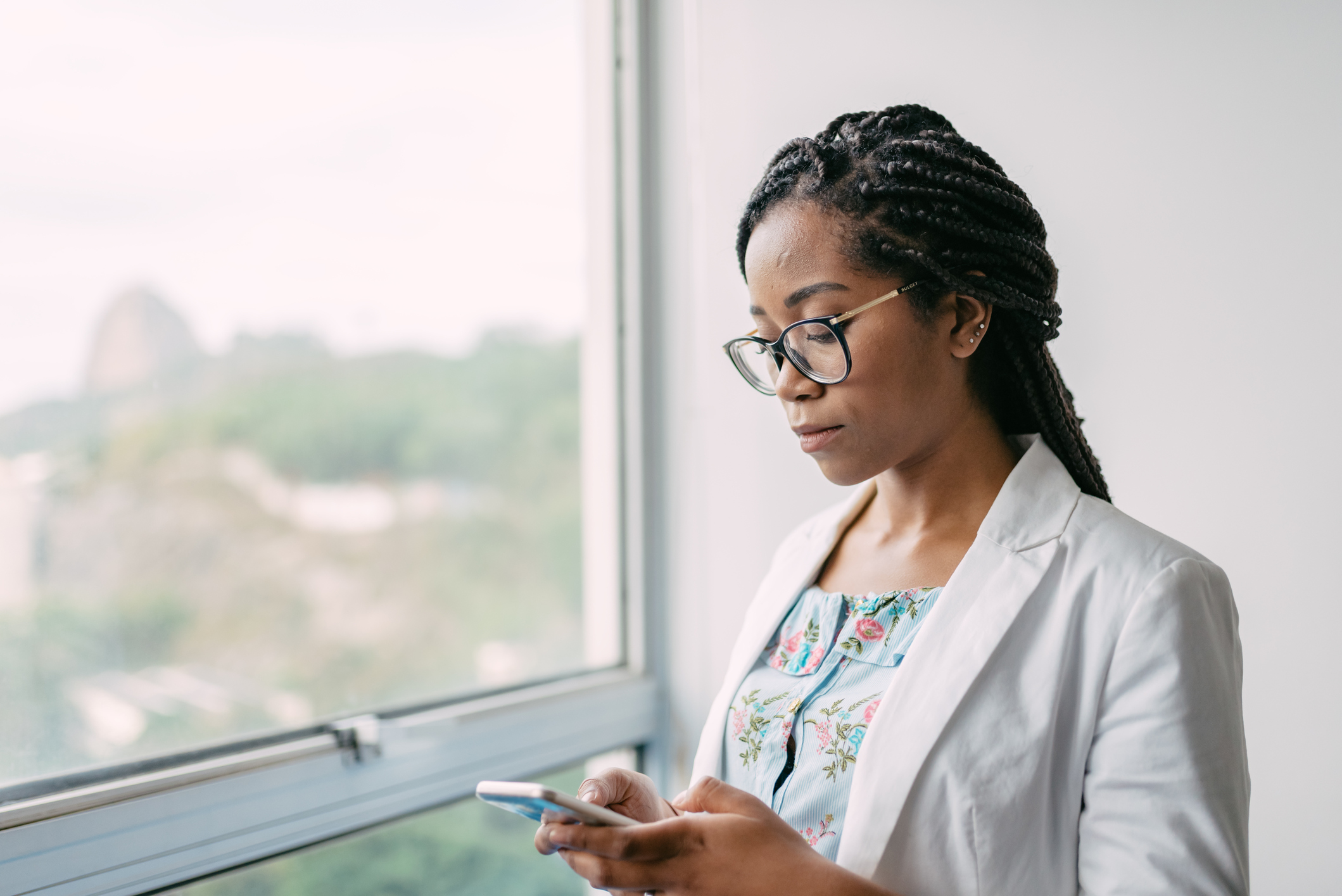 young brazilian businesswoman looking at mobile in office in Rio