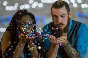 Couple Blowing Glitter Out of Their Hands