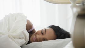 Mixed race woman sleeping in bed
