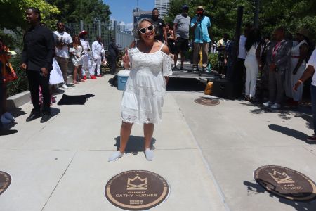 Cathy Hughes poses in front of her plaque