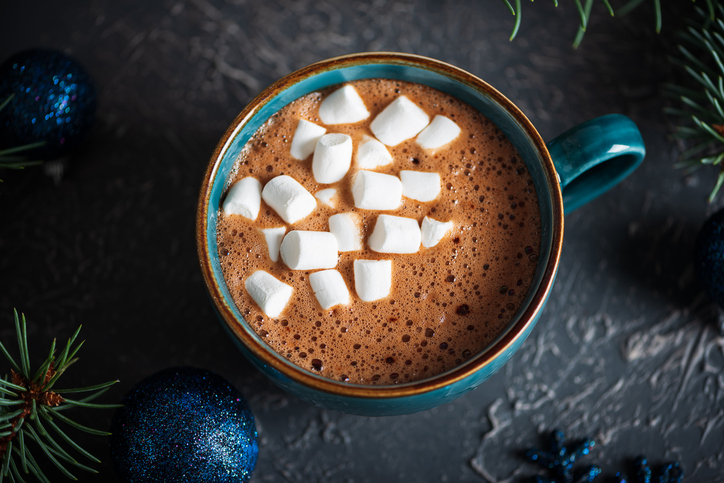 Hot Chocolate with Marshmallows in Teal Mug Surrounded by Christmas Decor
