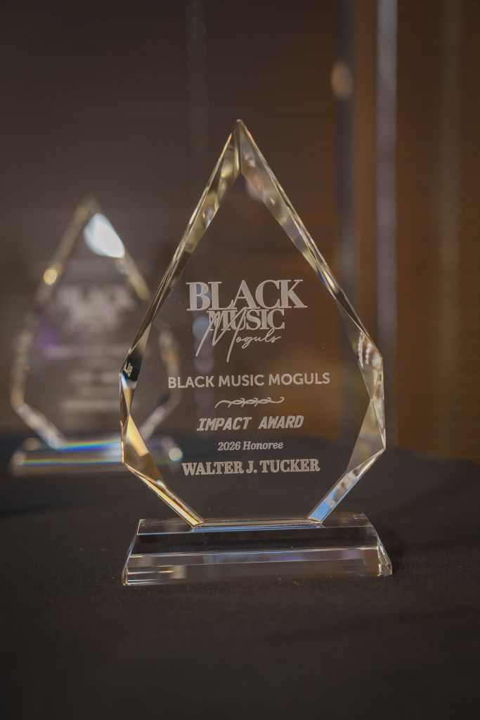 Crystal award with "BLACK MUSIC MOGULS" and "IMPACT AWARD 2026 Honoree WALTER J. TUCKER" engraved on it.