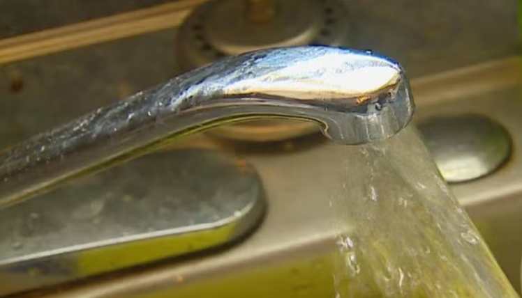 A close-up view of a faucet with running water.